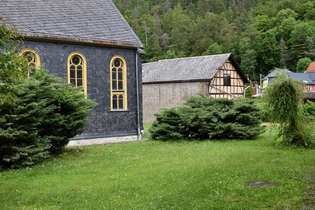 Schieferverkleidete Kirche mit goldgerahmten Fenstern im Bergischen Land