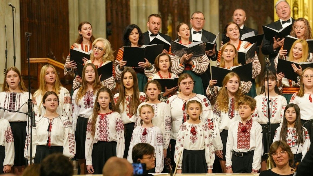 Mehrgenerationenchor singt mit Notenmappen in einer Kirche