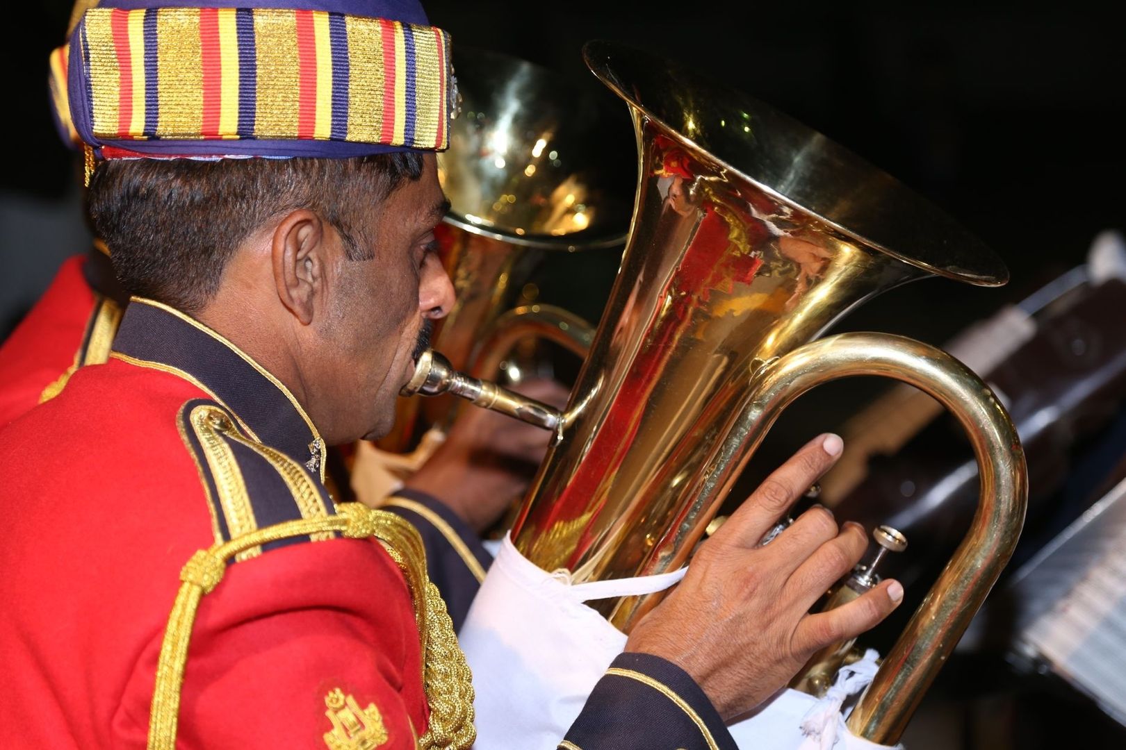 Musiker in roter Uniform spielt ein großes glänzendes Blechblasinstrument